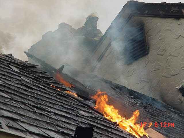 Crews working on the roof at a house fire in Pennsbury Twp.